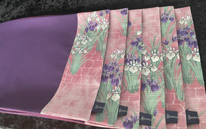 Napperons mauves avec des fleurs d&#39;iris sur des parements roses